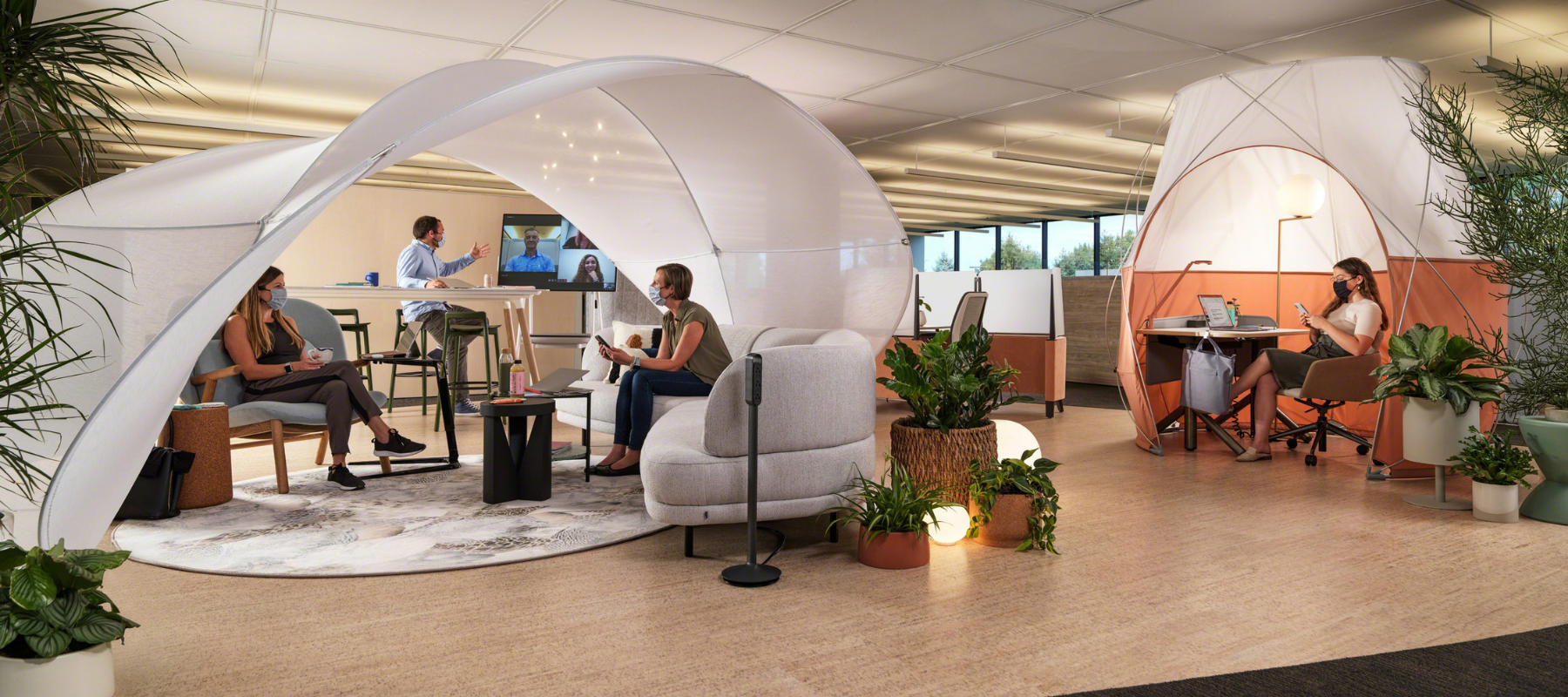 an office with work tents, collaboration areas, lots of plants, and a mix of focus spaces and meeting space