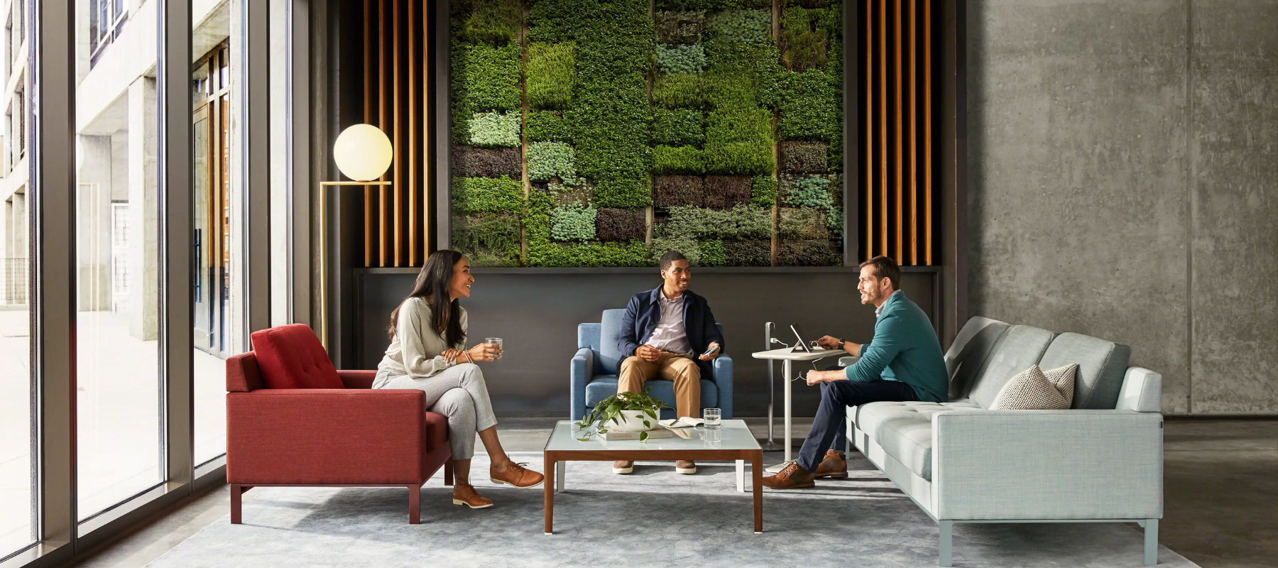 three people sitting at sofas in a residential-inspired workplace setting