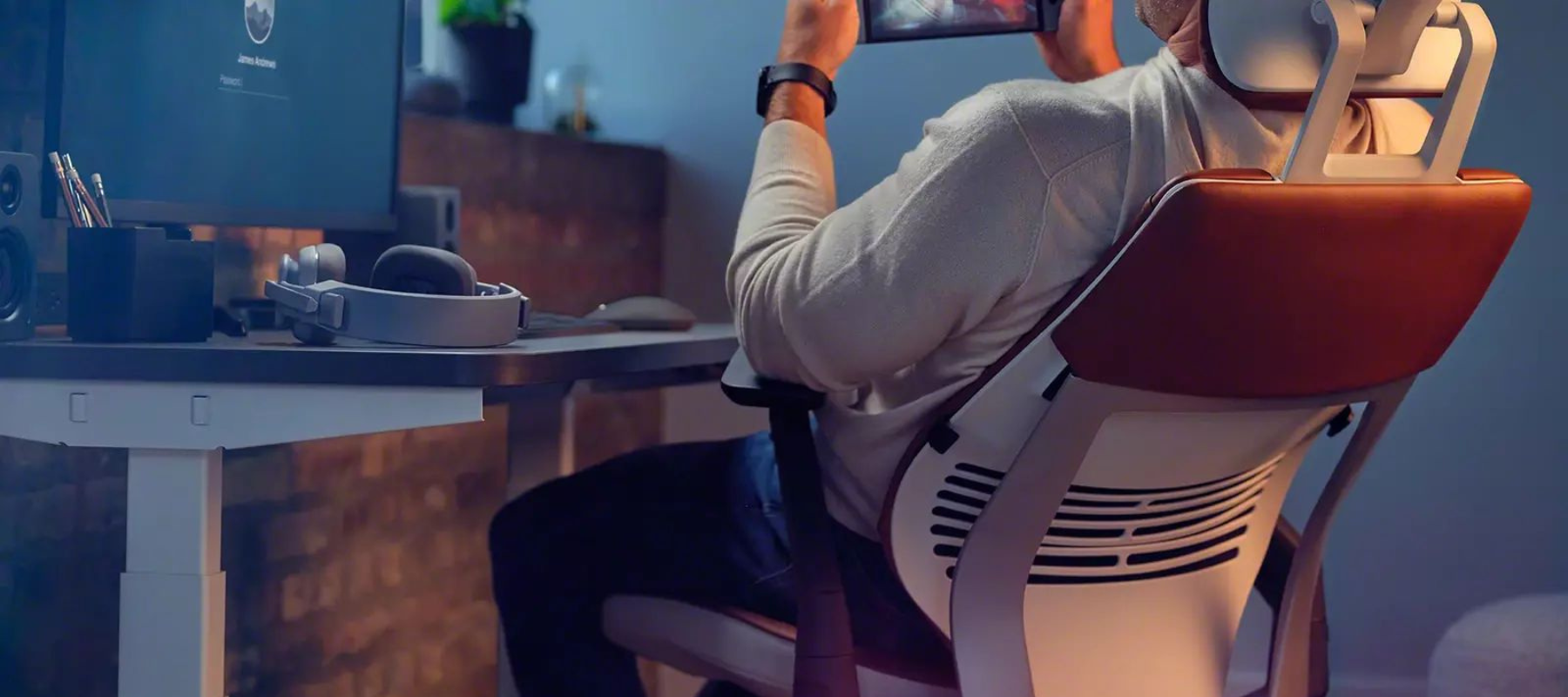 man leaning back in a gesture task chair using a mobile device